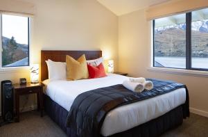 a bedroom with a bed and a window at Villa Del Lago in Queenstown