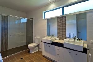 a bathroom with a toilet, sink, and shower at Quarterdecks Retreat in Hervey Bay