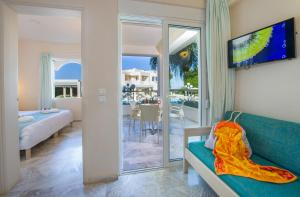 a living room with a couch and a sliding glass door at Kedrissos Hotel in Chania