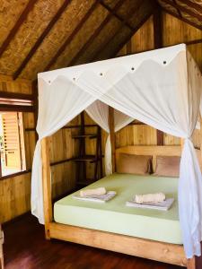 um quarto com uma cama num chalé de madeira em BaraCoco Bungalows em Bira