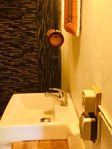 a white sink in a bathroom with a shower at BaraCoco Bungalows in Bira