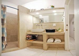 uma casa de banho com um lavatório e um espelho em HominngBird Acapulco em Acapulco