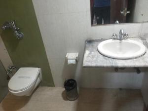 a bathroom with a sink and a toilet at Hotel Eastern Plaza in Kolkata