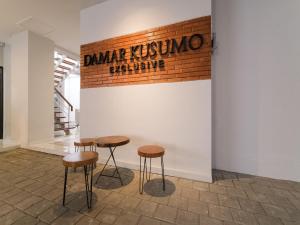 a group of stools in a room with a brick wall at Super OYO Collection O 90023 Damar Kusumo Guest House in Yogyakarta