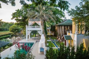 une piscine extérieure avec un toboggan et un parc aquatique dans l'établissement Rosario Oasis Resort SHA Plus, à San Sai