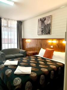 a hotel room with a bed and a zebra picture at Central Motel Mildura in Mildura +33 photos