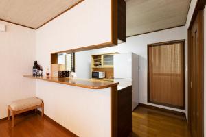 cocina con paredes blancas y encimera en una habitación en Shirakabanoyado - Ryogetsu, en Osaka