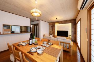 a dining room and living room with a table and chairs at Shirakabanoyado - Ryogetsu in Osaka