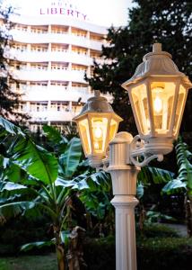 two lights on a pole in front of a building at Liberty Fly Hotel in Adler