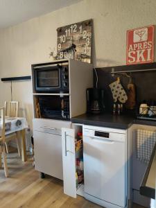 a kitchen with a counter with a microwave and a refrigerator at Studio avec jardin et garage, à 100m d'une piste in Les Deux Alpes