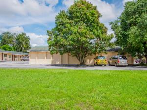 un edificio con dos coches estacionados en un estacionamiento en OYO Superior Budget Inn Bartow, en Bartow