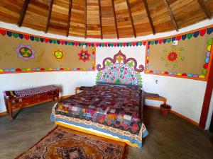 a bedroom with a bed in a room with painted walls at Banni Village Stay in Bherandiāla