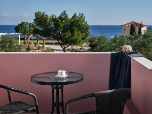 kubek kawy siedzący na stole na balkonie w obiekcie Periyali Villas with Private Pools w mieście Vasilikos