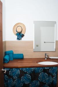 a bathroom with a sink and a hat on the wall at Le Neliza Beach Lodge Raiatea in Opoa