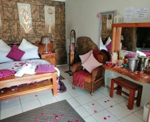 een slaapkamer met een bed, een stoel en een spiegel bij Castle Lodge in Boksburg