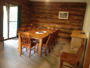 ein Esszimmer mit einem Holztisch und Stühlen in der Unterkunft Canobolas Mountain Cabins in Lidster