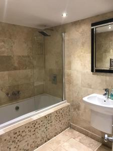 a bathroom with a bath tub and a sink at Ellison Hall in Hebburn-on-Tyne