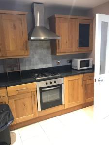 a kitchen with wooden cabinets and a stove top oven at Ellison Hall in Hebburn-on-Tyne