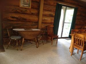 ein Esszimmer mit einem Tisch und Stühlen in einer Blockhütte in der Unterkunft Canobolas Mountain Cabins in Lidster