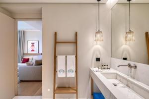 a bathroom with a sink and a mirror at Vathi Cove Luxury Resort & Spa in Chrysi Ammoudia
