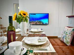 stół z butelką wina i telewizor na ścianie w obiekcie Sunset Beach House w mieście Chatan
