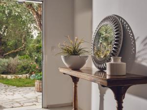 uno specchio su un tavolo con una pianta di Periyali Villas with Private Pools a Vasilikós