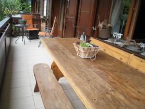 a large wooden table with a bench on a patio at Mila 4 in Champéry