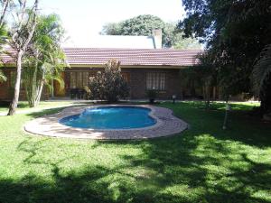 a swimming pool in the yard of a house at Lepha Guest House in Onverwacht