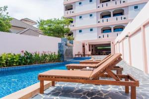 un patio al aire libre con bancos y una piscina en Saiyuan Residence, en Kata Beach