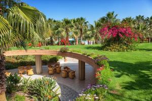 a garden with a bridge and chairs and flowers at Acacia Resort Parco Dei Leoni in Campofelice di Roccella