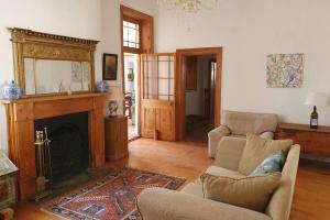 sala de estar con sofá y chimenea en Garden House en Graaff-Reinet