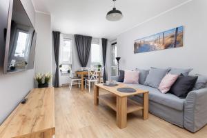 a living room with a couch and a table at Apartamenty PLATANY z Parkingiem by Renters in Kołobrzeg