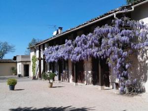 Saint-Jean-de-ThurigneuxにあるLes Barellesの紫色の花束が咲き誇る建物