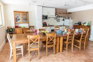 Les Barelles في Saint-Jean-de-Thurigneux: مطبخ مع طاولة وكراسي غرفة طعام خشبية