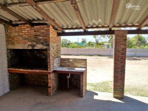 an outdoor brick oven with a wooden roof at Cabañas Barra Linda in Barra del Chuy