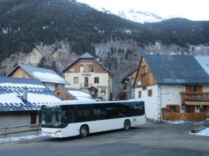 een bus geparkeerd op een parkeerplaats in een dorp bij Chalet 1200 in Saint-François-Longchamp