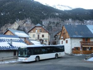 ein Bus parkt auf einem Parkplatz in einem Dorf in der Unterkunft Chalet 1200 in Saint-François-Longchamp + 13 Fotos