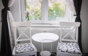 two chairs and a table in front of a window at Pension Bertha in Jena