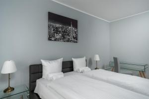 ヴロツワフにあるRentPlanet - Apartamenty Atal Towerのベッドルーム1室(白いベッド2台、テーブル付)