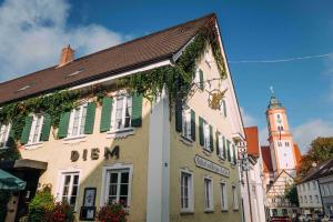 a building in a town with a clock tower at Gasthof Diem in Krumbach
