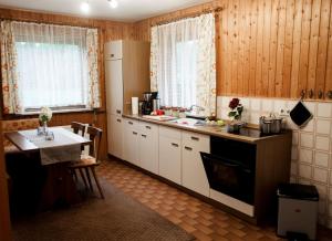 a kitchen with a refrigerator and a table in it at Ferienhaus Fischer in Sörup