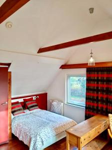 a bedroom with a bed and a table and a window at Appartement Soerte Es in Wapse