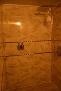 baño con ducha y puerta de cristal en CİHANGİR KONAĞI BUTİK OTEL, en Sanlıurfa