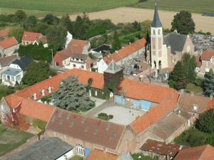 uma vista aérea de uma pequena cidade com uma igreja em La Ferme de la Sensée em Gouy-sous-Bellonne