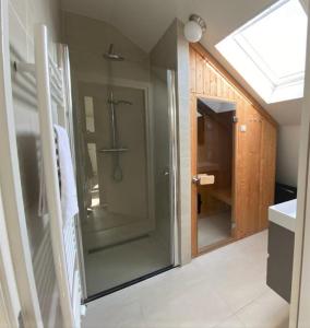 een badkamer met een douche en een glazen deur bij Zonnestralen Egmond in Egmond aan den Hoef