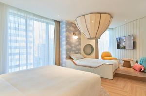 a bedroom with two beds and a large window at Grand Josun Busan in Busan