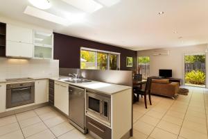 cocina abierta y sala de estar con comedor en Quarterdecks Retreat en Hervey Bay