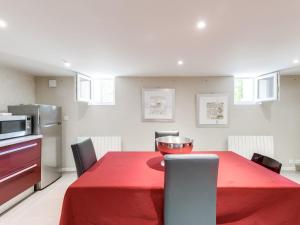 a dining room with a red table and chairs at Loft Fraternité in Bagnolet
