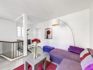 sala de estar con sofá púrpura y mesa en Loft Fraternité en Bagnolet