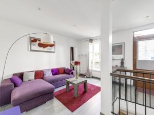 Loft Fraternité في بانيوليه: غرفة معيشة مع أريكة أرجوانية وطاولة